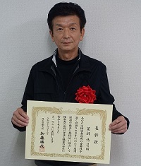 表彰状を持つ薬師氏